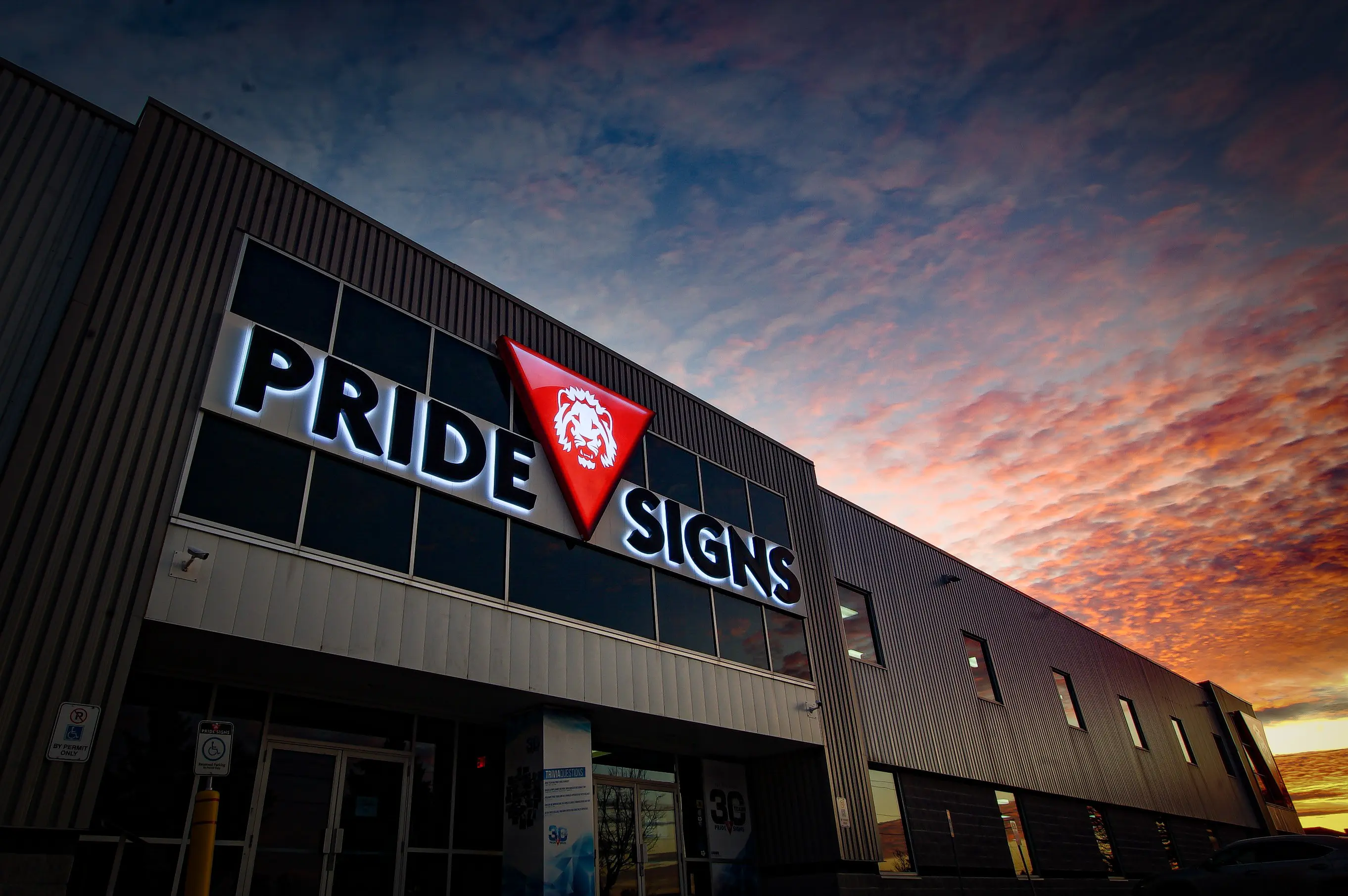 Original Pride Signs building with backlit channel letters at sunset