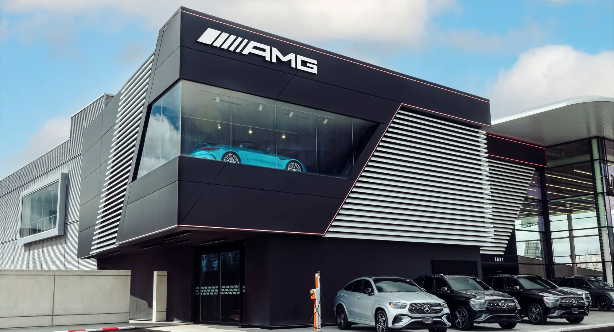 AMG brand centre clad in dark architectural panels with an illuminated showroom window