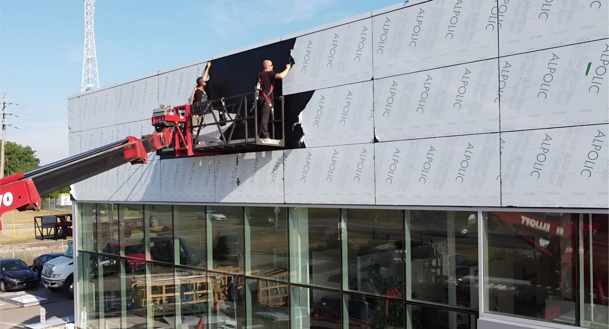 Two installers positioning a cladding panel from a lift