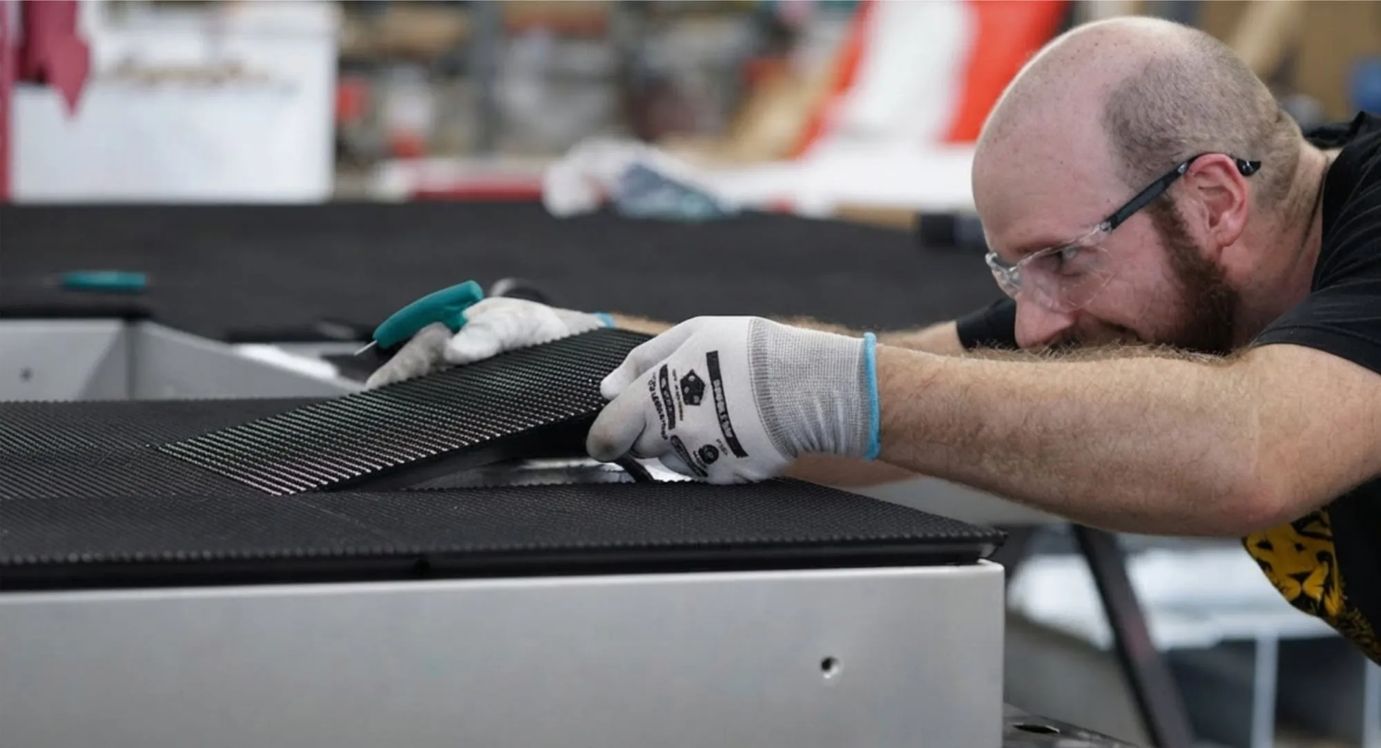 Craftsperson finishing a fabricated sign face in the Cambridge shop