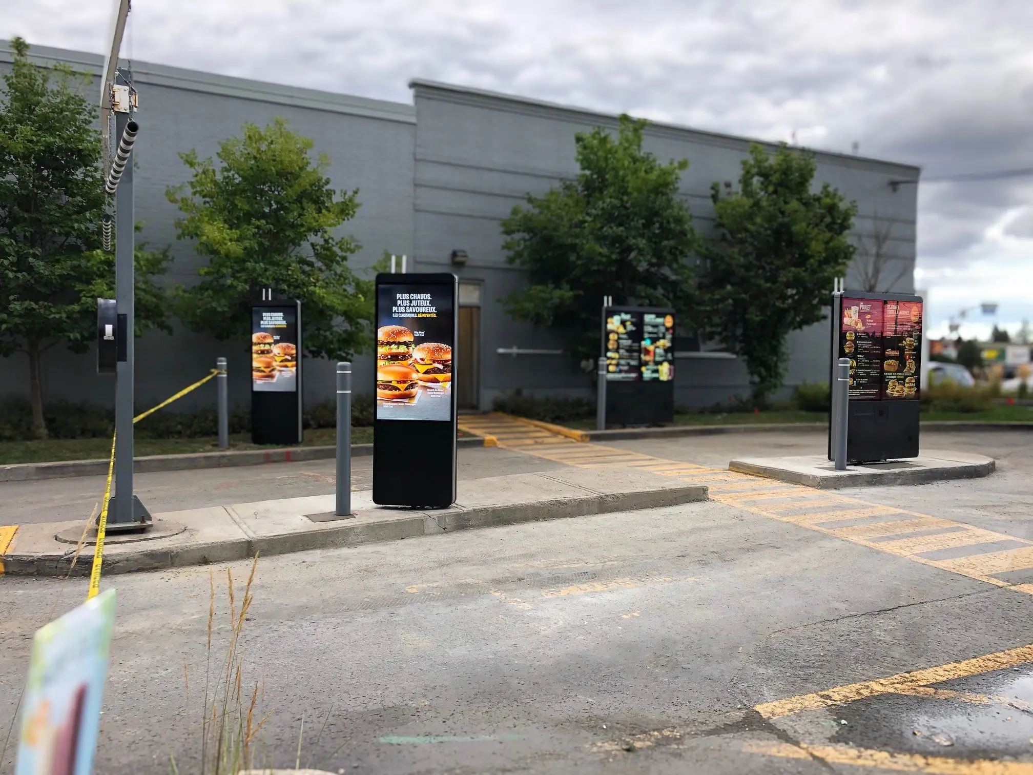 Completed drive-thru digital menu boards on a finished concrete island