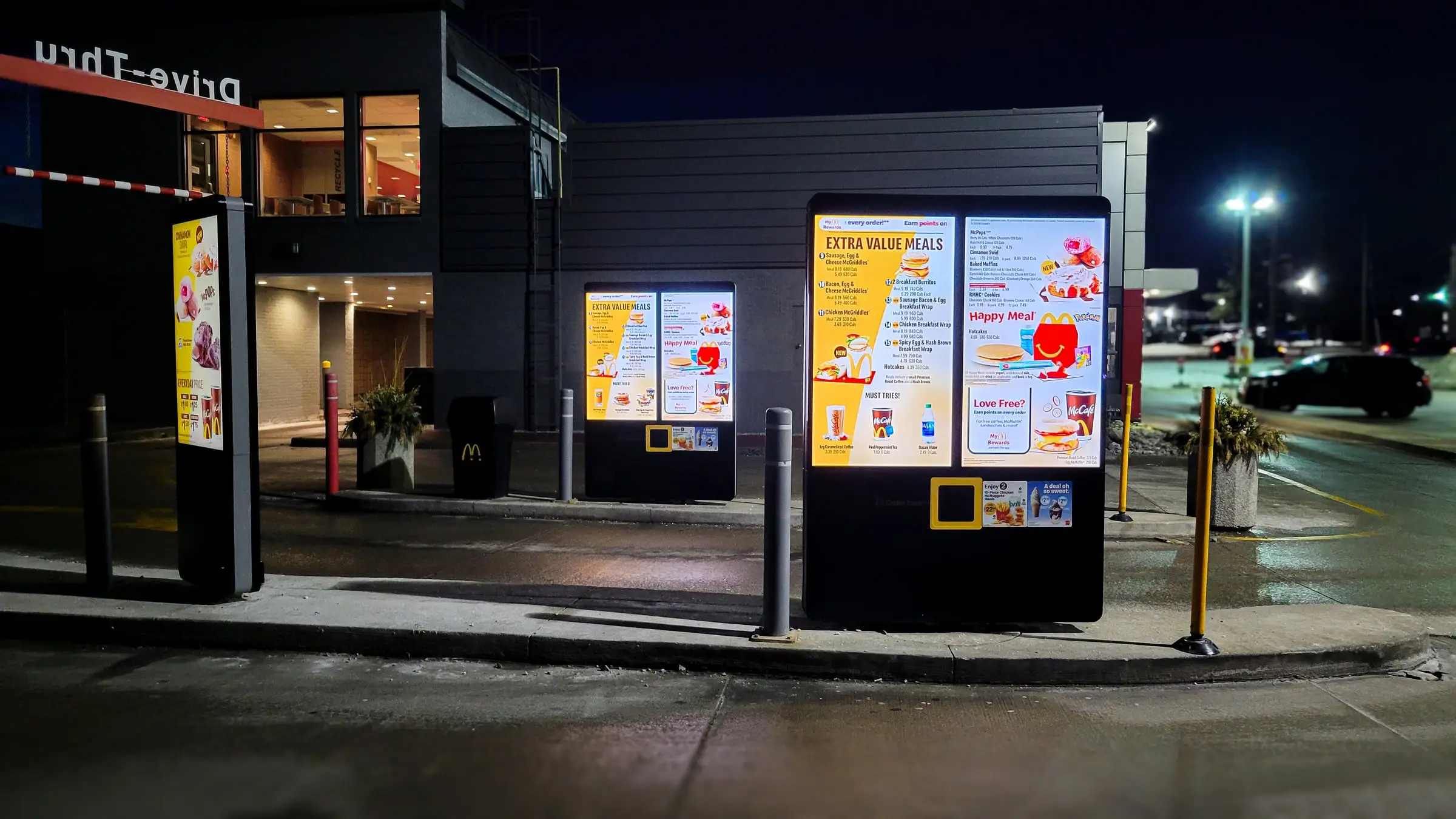 Illuminated drive-thru digital menu boards at night after installation