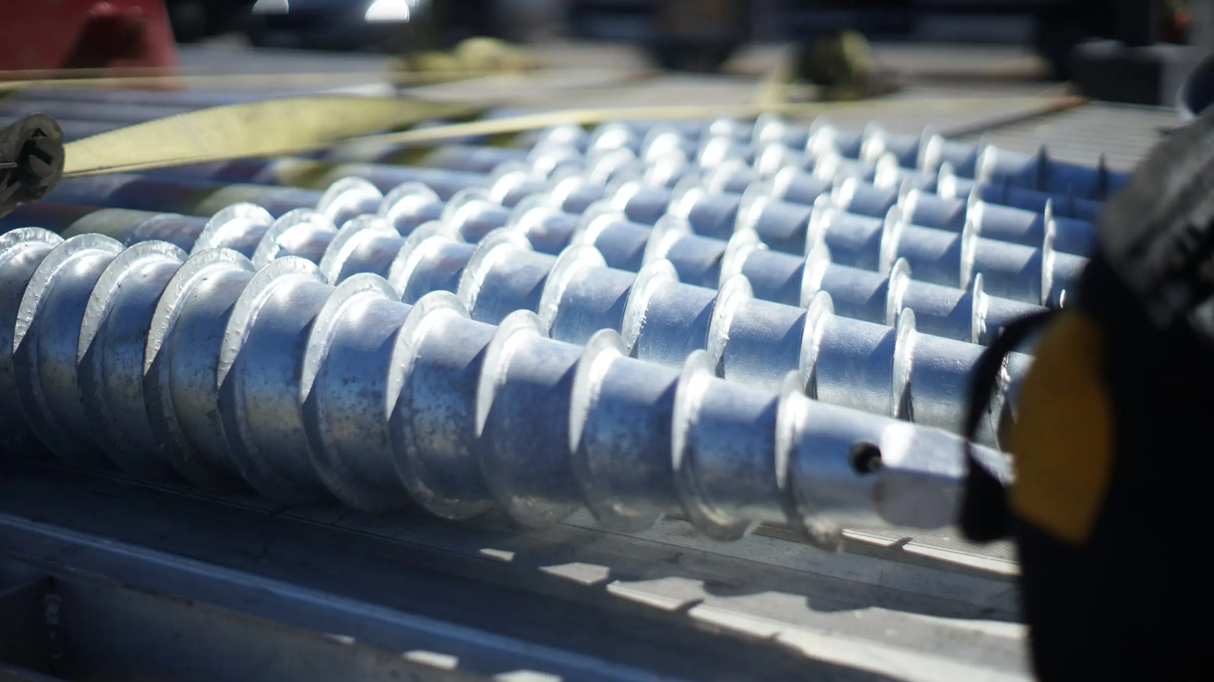 Galvanized helical ground screws racked on a truck bed, ready for installation